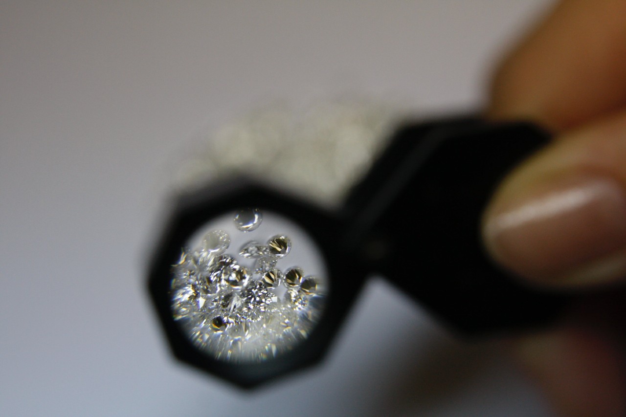 A magnifying view of a bunch of diamonds from a magnifying glass.